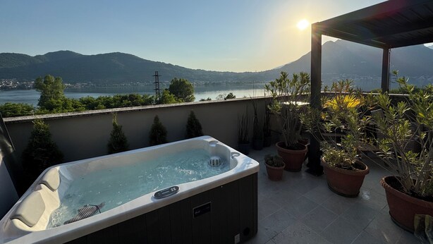 A hot tub on a balcony with a view of a lake and mountains. - Felicita – Cascata Terrace with Lake View (Lecco)