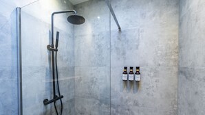 A shower with a handheld showerhead and a wall-mounted faucet, and three bottles of shampoo on the wall. - In the Heart of Ghent | Charming Private Room (Ghent)