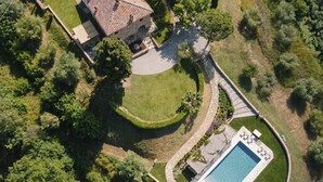 An aerial view of a property with a swimming pool, a stone building, and surrounding greenery. - "Poggio del Pero" by Interhome (Panicale)