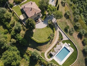 An aerial view of a property with a swimming pool, a stone building, and surrounding greenery. - "Poggio del Pero" by Interhome (Panicale)