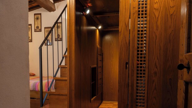 A wooden staircase leading to a bedroom with a bed and a nightstand. - "Poggio del Pero" by Interhome (Panicale)