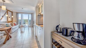 A modern kitchen with a dining area, a coffee maker, and a toaster. - Couples Retreat in Houlgate with Spa (Houlgate)