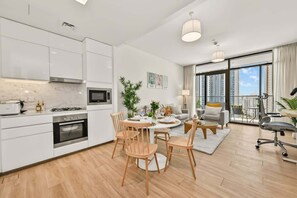 Ein modernes Apartment mit Küche, Essbereich und Wohnzimmer mit großen Fenstern.