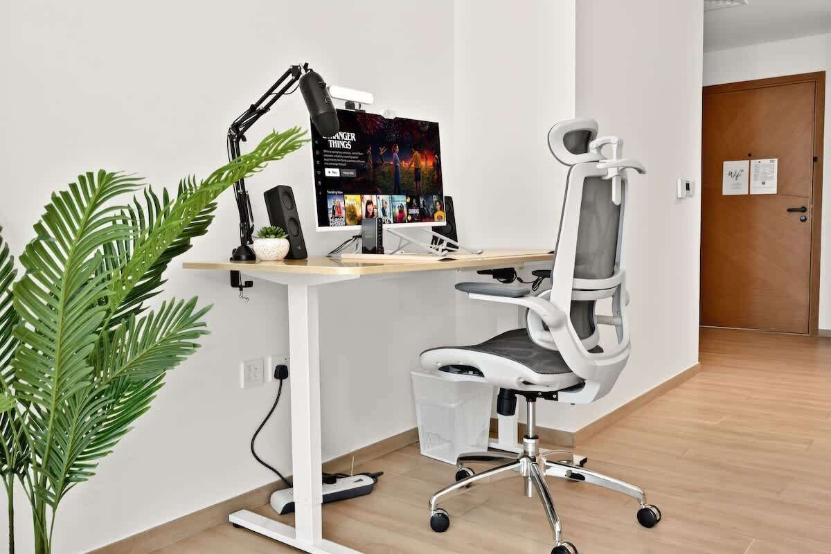 Despatx modern amb escriptori, ordinador i cadira ergonòmica.