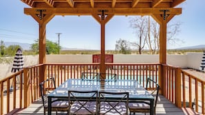 A wooden deck with a glass table and chairs, overlooking a pool and desert landscape. - Home w/ Outdoor Oasis & Views in Borrego Springs! (Borrego Springs)