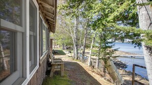 A wooden cabin with a porch, a bench, and a view of a lake. - Fun on Gull Lake! Family Cabin w/ Resort Perks (Tenstrike)