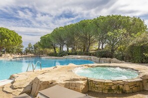 A swimming pool with a hot tub, surrounded by trees and a stone deck. - Riverside Stay with Shared Pools (Mallemort)