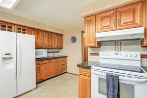 A kitchen with wooden cabinets, a white refrigerator, a microwave, and an oven. - Extended-Stay Home/Office, 8 Mi to Dtwn Denver (Lakewood)