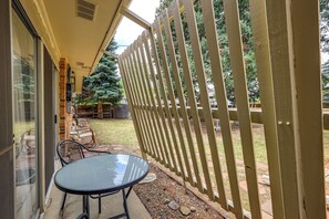 A patio with a table and chairs, a wooden fence, and a view of a yard with trees. - Extended-Stay Home/Office, 8 Mi to Dtwn Denver (Lakewood)