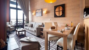 Una sala de estar moderna con sofá, mesa de centro y mesa de comedor.