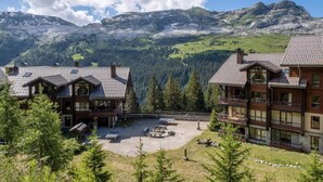 Eine Lodge mit mehreren Gebäuden, einem Innenhof und einer Bergkulisse.