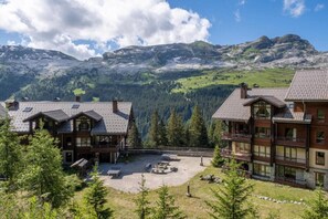 Eine Lodge mit mehreren Gebäuden, einem Innenhof und einer Bergkulisse.