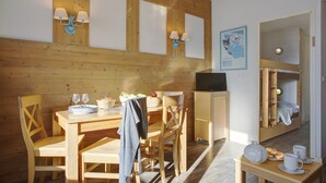 A wooden dining area with a table, chairs, and a small table with cups and a teapot. - Stunning Pyrenees Apartment for 4 (Font Romeu Ermitage)