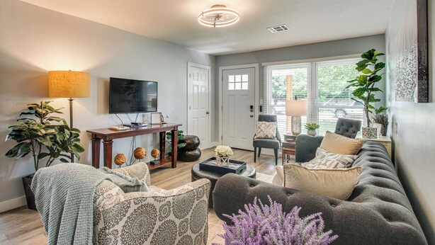 A living room with a sofa, armchairs, a coffee table, a TV, and a plant. - 2 Mi to OKC Fairgrounds: Pet-Friendly Home w/ Yard (Oklahoma City)