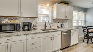 A modern kitchen with white cabinetry, a built-in microwave, a coffee maker, and a sink. - 2 Mi to OKC Fairgrounds: Pet-Friendly Home w/ Yard (Oklahoma City)