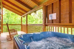 Eine Holzterrasse mit Whirlpool, Holzgeländern und einem Stuhl.