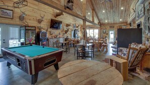 A wooden interior with a pool table, dining area, and various mounted animal heads. - Birch Haven Resort Cabin w/ Deck: Boating On-Site (Tenstrike)