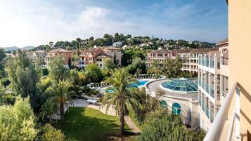 Un hôtel composé de plusieurs bâtiments, doté d’une piscine et entouré d’une végétation luxuriante.
