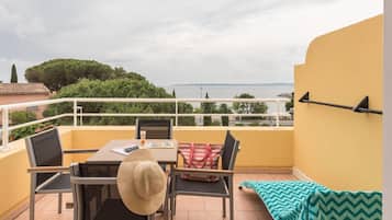Ein Balkon mit Tisch, Stühlen und Blick auf das Meer.