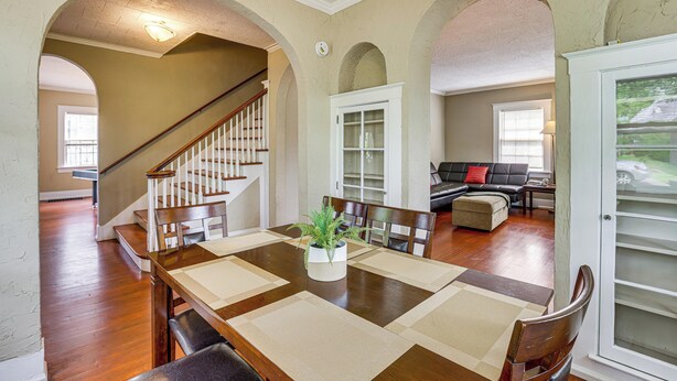 A dining area with a wooden table, chairs, and a potted plant. There is a staircase leading to another room. - 2-Unit Combo w/ Game Room, 2 Mi to Uptown! (Birmingham)