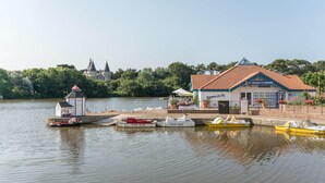 Uitzicht over een meer met een klein gebouw, een brandboot en een veerboot die aan de waterkant ligt.