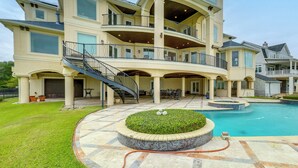 Ein mehrgeschossiges Haus mit Swimmingpool, Sitzgelegenheiten im Freien und einer überdachten Terrasse.