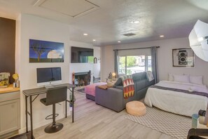 Ein modernes Zimmer mit Bett, Sofa, Schreibtisch und Computer.