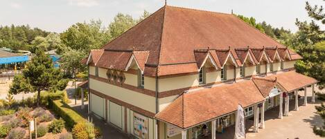 A building with a tiled roof, a covered walkway, and a landscaped garden.