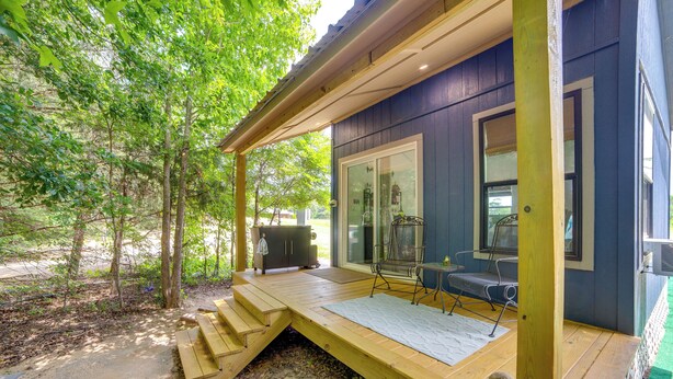 A covered outdoor deck with a wooden bench, a table, and a grill area. - ‘Tweet Suite’ - Studio Getaway 7 Mi to Dtwn Tyler (Tyler)