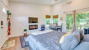 A bedroom with a bed, a ceiling fan, a TV, a window with a view, and a door. - ‘Tweet Suite’ - Studio Getaway 7 Mi to Dtwn Tyler (Tyler)