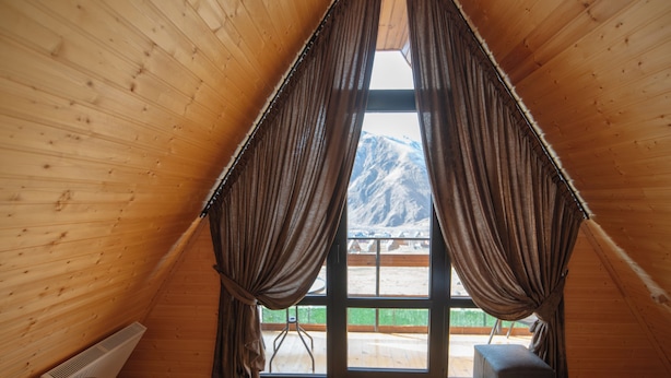 A wooden cabin room with a large window, two beds, and a view of a snowy mountain. - Welcome to our property ❤️ Cozy house in mountains (Stepantsminda)