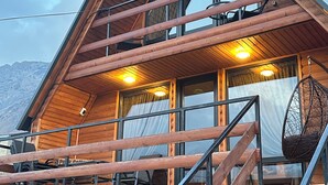 A wooden cabin with a balcony, stairs, and a hanging chair. - Welcome to our property ❤️ Cozy house in mountains (Stepantsminda)