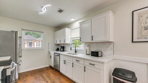 A kitchen with white cabinets, a stainless steel refrigerator, a dishwasher, and a marble countertop. - Easy Access to Dtwn & Fort Benning: Family Home (Columbus)