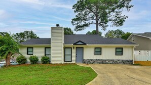 A single-story house with a front yard, a chimney, and a stone foundation. - Easy Access to Dtwn & Fort Benning: Family Home (Columbus)