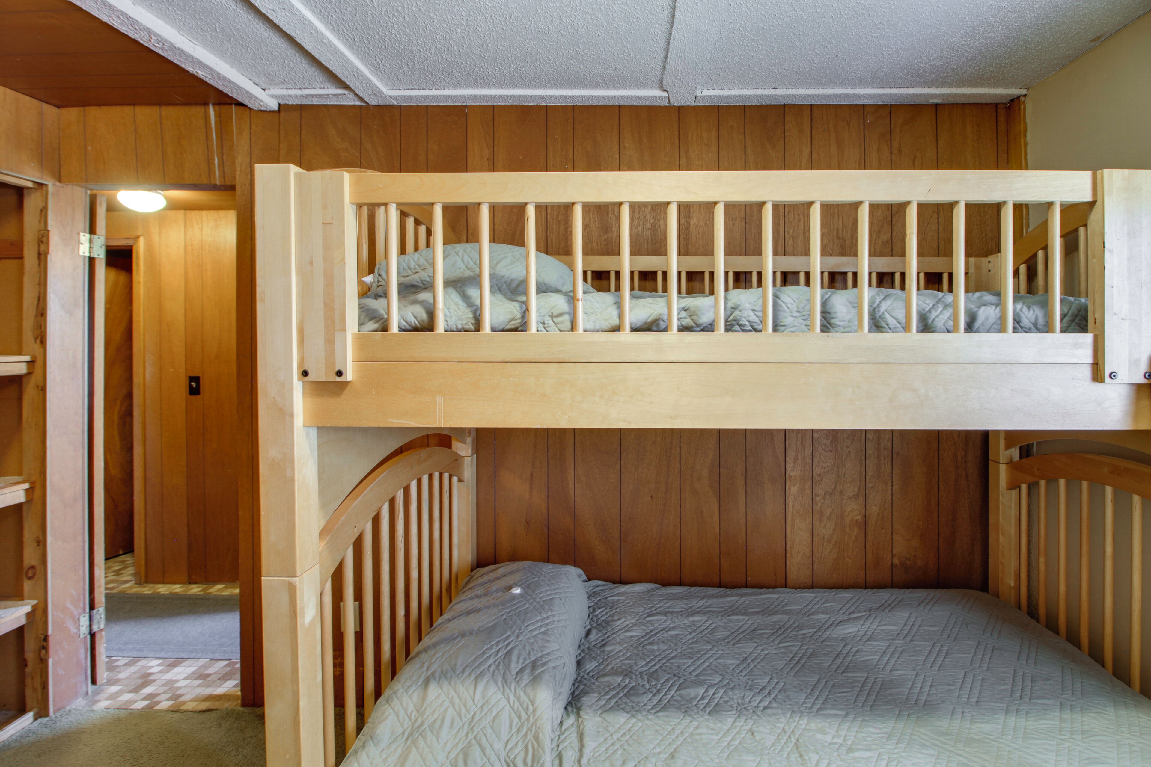 A bunk bed with a wooden headboard and a lower bed with a quilted mattress.