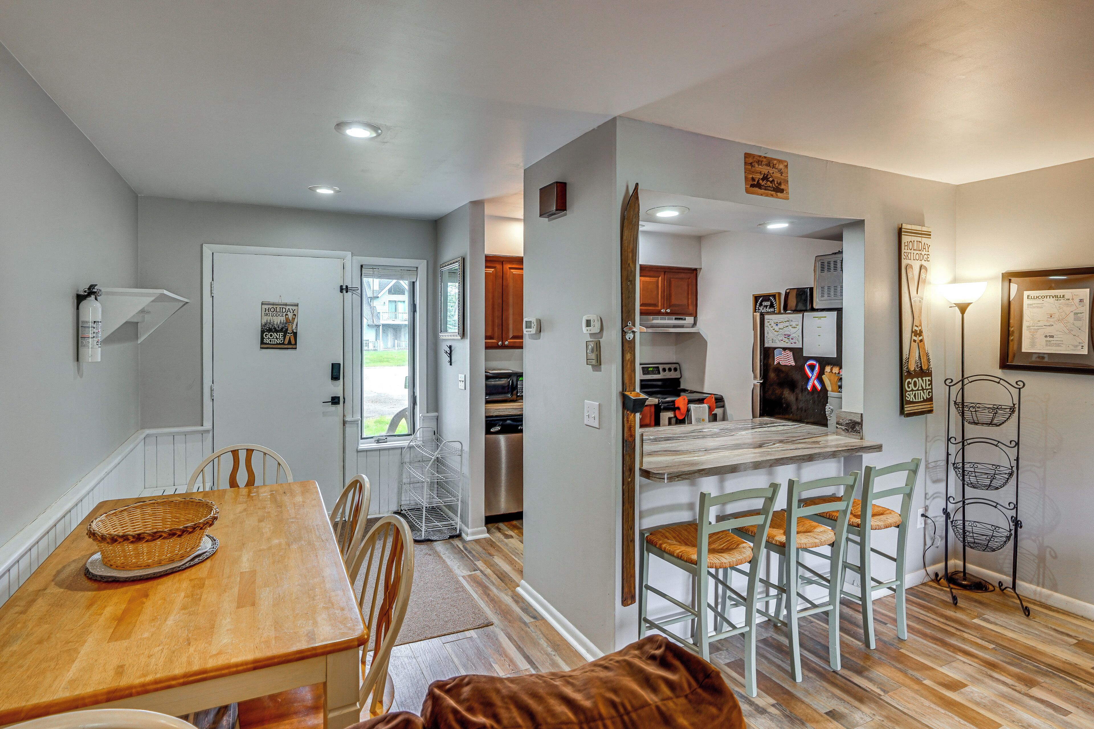 A modern kitchen with a central island, wooden dining table, and chairs.