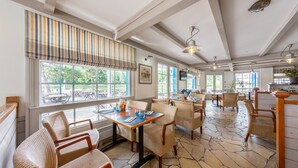 Ein Restaurant mit Außenbereich, Steinböden und Holzmöbeln.