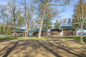 Ein Campingplatz mit Holzhütten, einem Boden aus Erde und Bäumen.