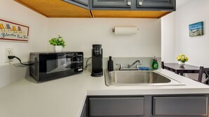 A kitchen with a microwave, coffee maker, sink, and a small table with a plant. - Steps to Beach, Boardwalk & Eats! Ocean Grove Unit (Ocean Grove)