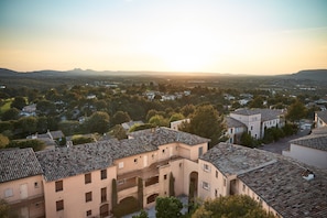 Un quartier résidentiel où les bâtiments présentent une architecture traditionnelle, avec un patio et une vue sur des collines lointaines.