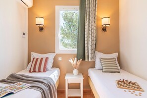 A twin room with two beds, a window, a small table with a vase, and wall-mounted lamps. - Stay with Private Outdoor Space (Mallemort)