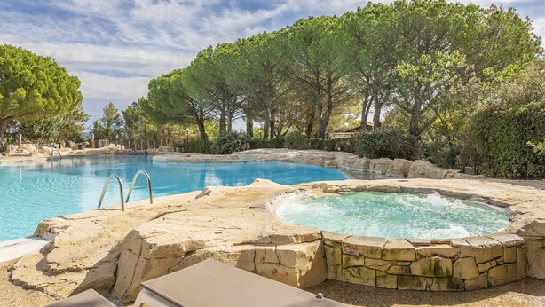 A swimming pool with a hot tub, surrounded by trees and a rocky landscape. - Chic Countryside Stay with Balcony (Mallemort)