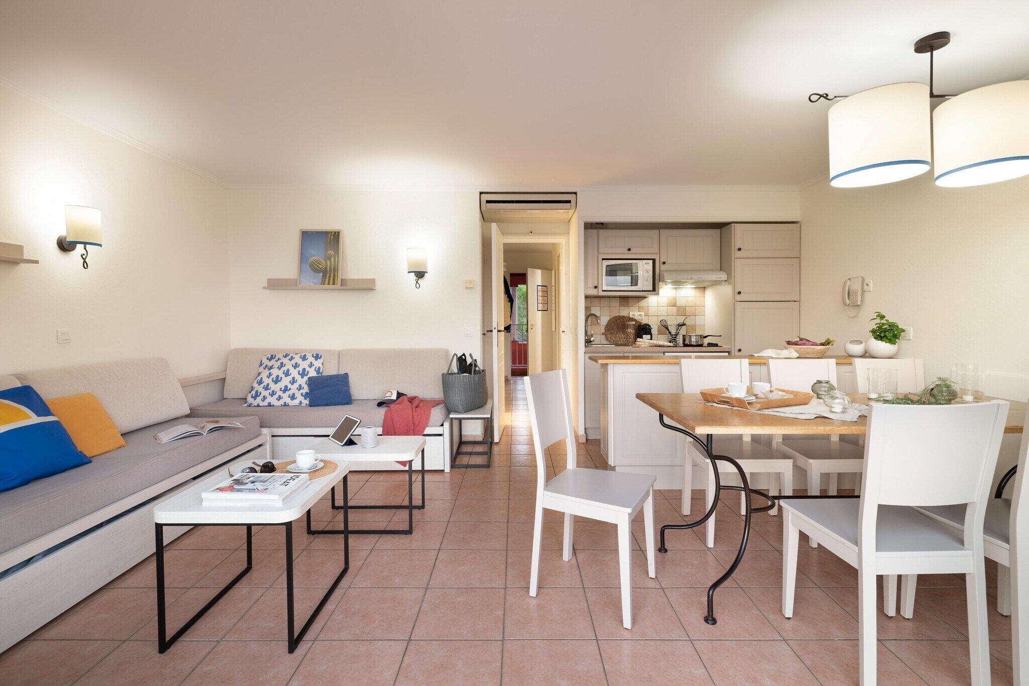 Un salon moderne avec un canapé, une table basse et un coin repas.