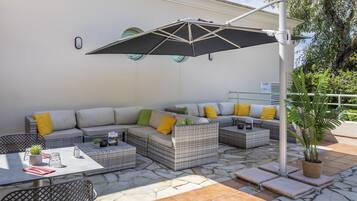 An outdoor seating area with a sectional sofa, a table, and a potted plant.