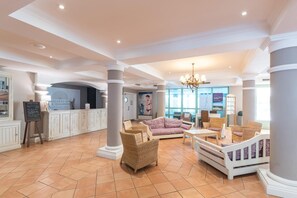 A spacious lobby with a reception desk, wicker furniture, and a large poster on the wall. - Stunning 4-Person Sea View Haven (Les Issambres)