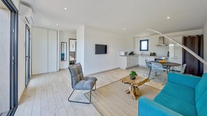 Ein modernes Apartment mit Wohnzimmer, Küche und Essbereich.