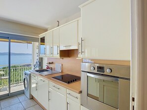 A kitchen with a built-in oven, a sink, and cabinets. - Le Palais de la Mer by Interhome (Sainte Maxime)