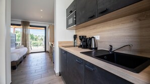 Une cuisine moderne avec un évier noir, un plan de travail en bois et des armoires noires.