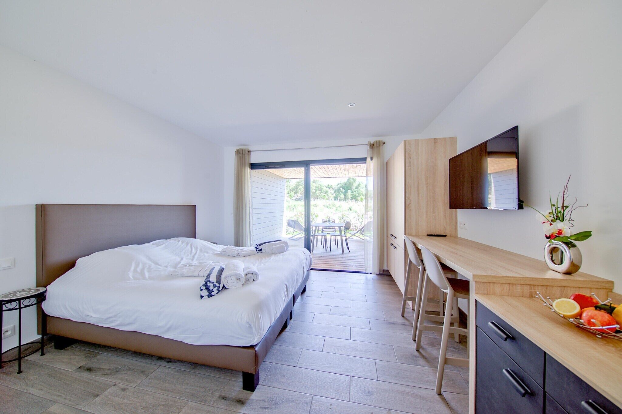 Une chambre comprenant un lit, un bureau et un coin repas avec une table et des chaises.