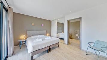 Una habitación de hotel moderna con una cama grande, mesitas de noche, una silla y un espejo.